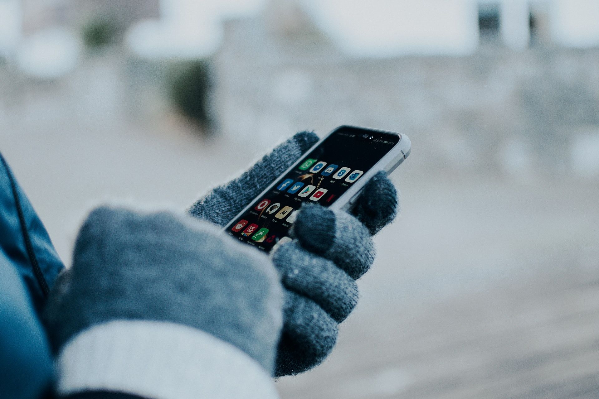 person using phone with gloves