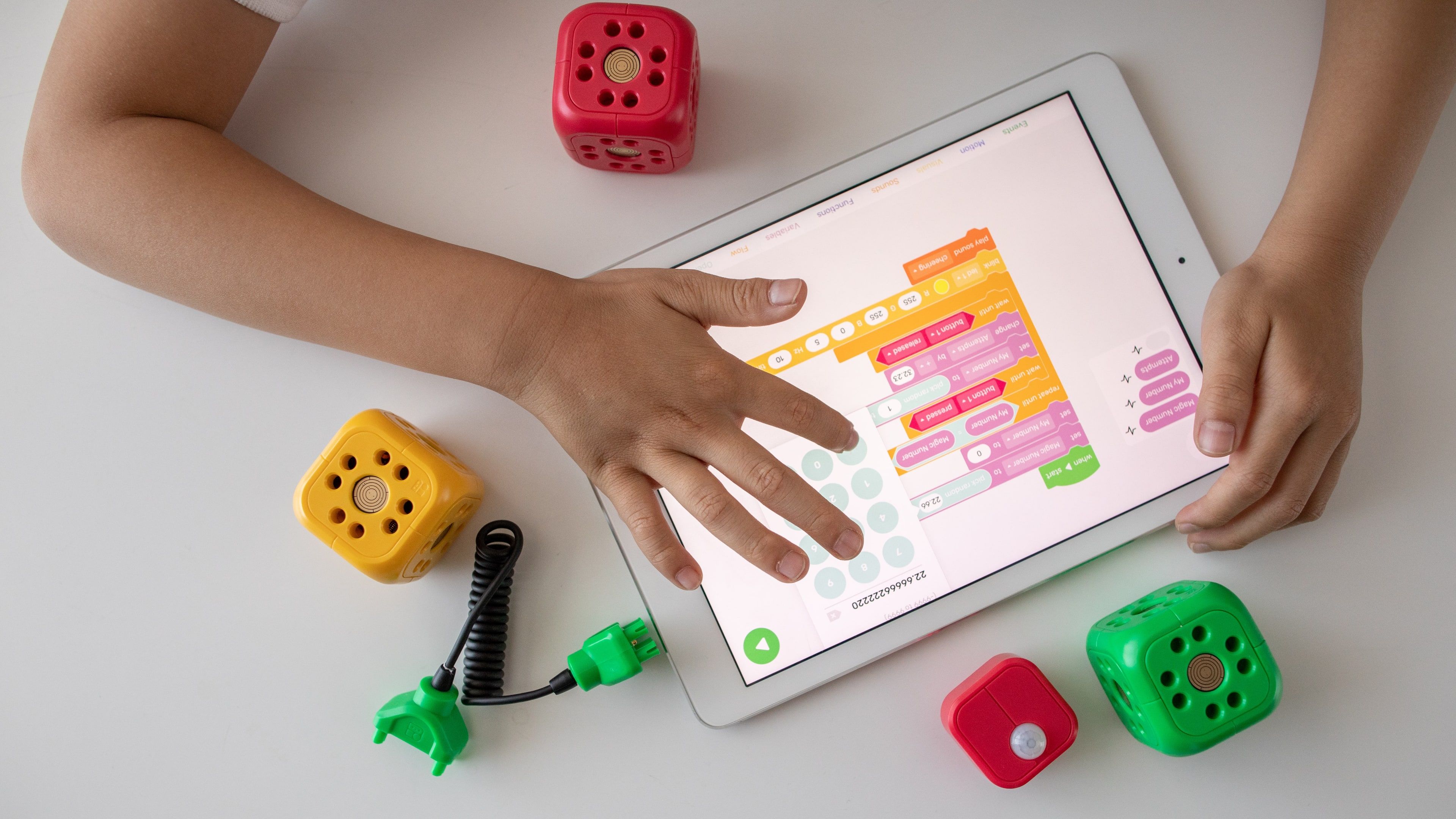 A kid interacting with an iPad app for visual programming