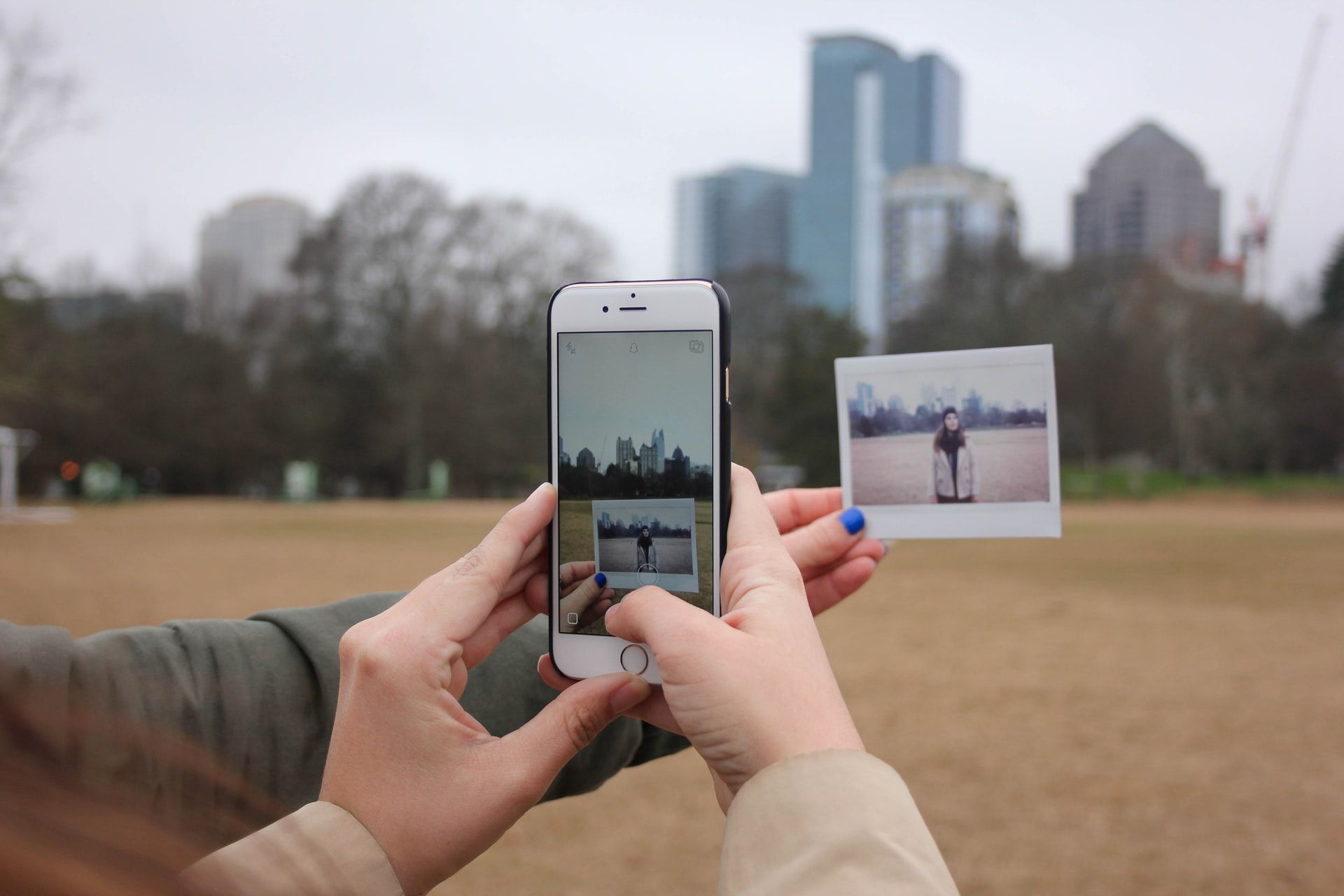 iphone taking photo of polaroid picture in park