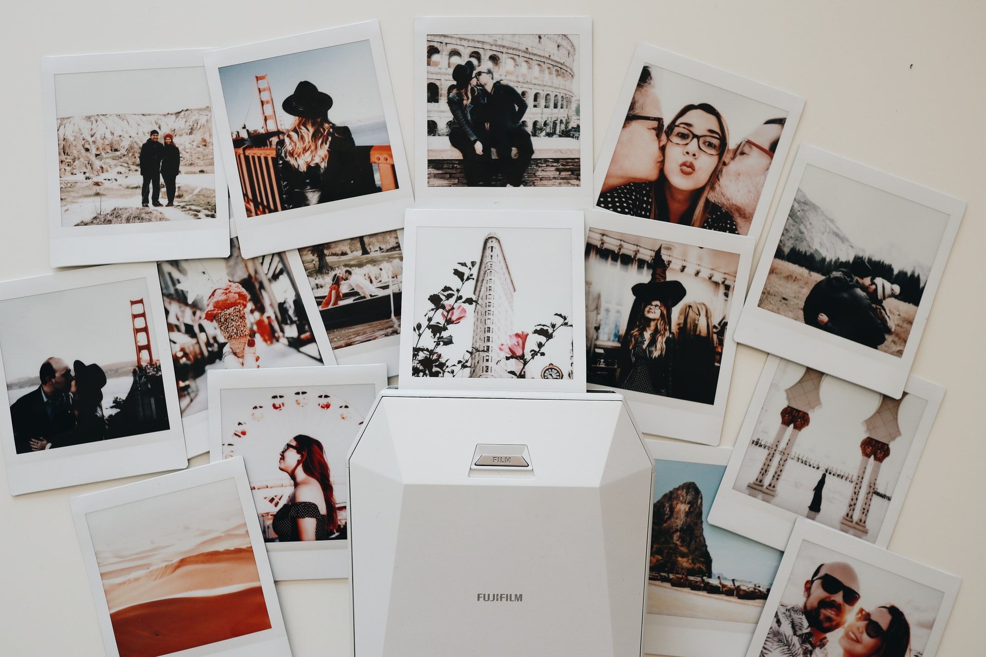 polaroid photos scattered on table of multiple portraits